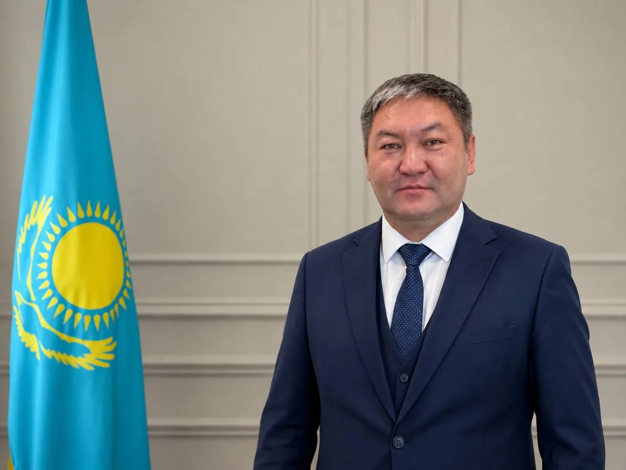Данияр Мукажанов, директор QMD, портрет у флага Республики Казахстан
